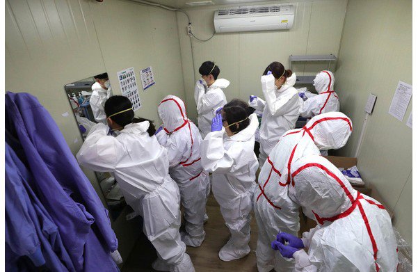 Các nhân viên y tế chuẩn bị làm việc tại một cơ sở xét nghiệm COVID-19 ở Daegu