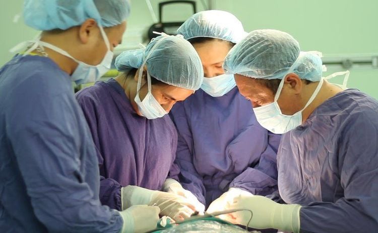 
Professor Tran Thiet Son (far right) performs surgery for Mr. Su
