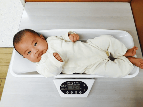 How much weight does a newborn baby gain in the first month of life?